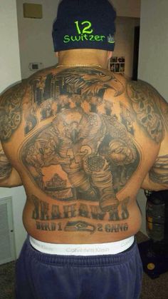 the back of a man with tattoos on his body