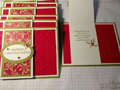 some red and green cards with gold trimmings are on a cutting board next to a piece of paper that says, happy christmas wishes