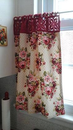 the curtains are hanging on the window sill in the room that is decorated with red and pink flowers