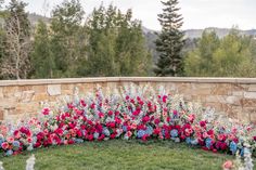 a circular flower bed in front of a stone wall