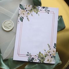 an envelope with flowers on it next to a wax stamp and some satin ribbon around it