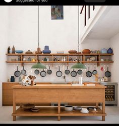 an image of a kitchen setting with pots and pans on the shelf above it