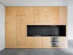 an empty kitchen with wood paneling on the wall