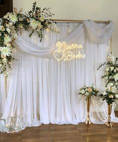 the backdrop is decorated with white flowers and greenery