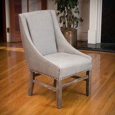 a white chair sitting on top of a hard wood floor next to a fire place