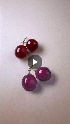 three cherries sitting on top of a table next to an empty piece of paper