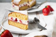 two slices of cake on plates with strawberries