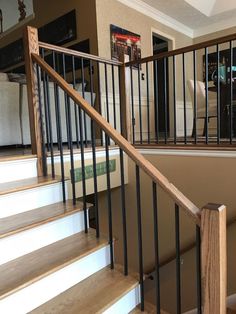 there is a stair case in the middle of this room with wood and metal handrails