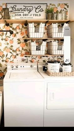 a washer and dryer in a small room with floral wallpaper on the walls