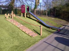 a playground with slide and climbing bars in the grass