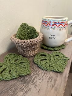 two crocheted coasters and a coffee mug on a table