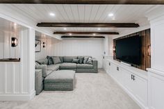 a living room filled with furniture and a flat screen tv mounted to the side of a wall