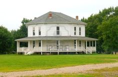 a large white house sitting on top of a lush green field