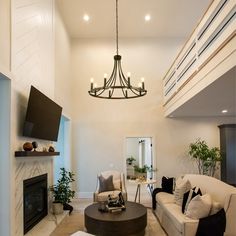 a living room filled with furniture and a flat screen tv mounted on the wall above it