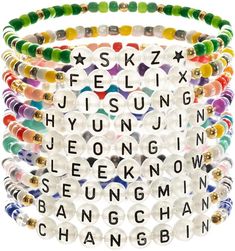 a stack of bracelets with words written in different colors and shapes on them, all stacked together