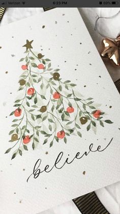 a card with a christmas tree on it and the words believe written in cursive writing