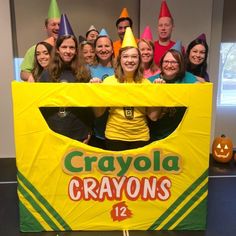 a group of people posing in front of a crayons sign