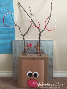 a cardboard box with some branches in it and a reindeer face on the side,