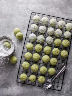 a cooling rack filled with green cookies and powdered sugar