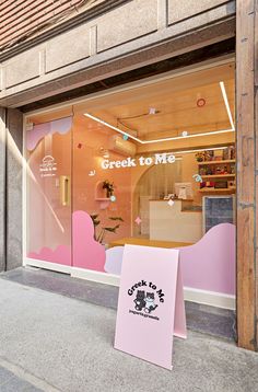 there is a pink sign in front of the store window that says creek to me