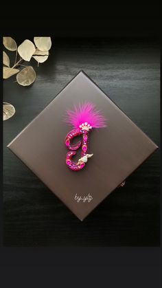 a pink brooch sitting on top of a black table