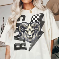 a woman wearing a white tshirt with an image of a ram on it