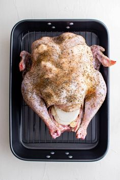 a roasting pan with a whole chicken on it's side, ready to be cooked