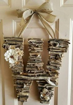 a door hanger made out of drift wood with flowers on the front and back