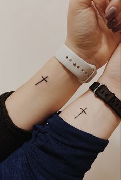 two wrist tattoos with crosses on them