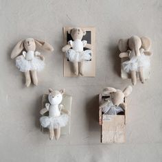 four stuffed animals in white tutus and dresses