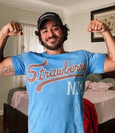 a man in a blue shirt flexing his muscles