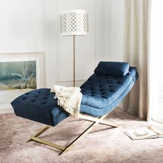 a blue chaise lounge chair sitting on top of a rug in a living room