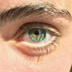 an extreme close up shot of the eye of a man with blue eyes and brown hair