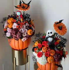 two pumpkins decorated with flowers and decorations