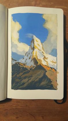 an open book with a painting of a mountain in the middle and clouds above it