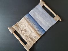 a piece of cloth with wooden handles on a black surface