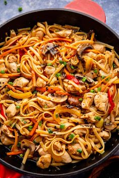 a skillet filled with noodles, chicken and vegetables