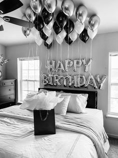 a bedroom decorated with balloons and streamers for a happy birthday message on the wall