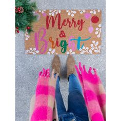 two feet in front of a merry and bright door mat