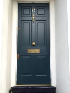 a blue front door with gold trim and number 13 on the bottom part of it