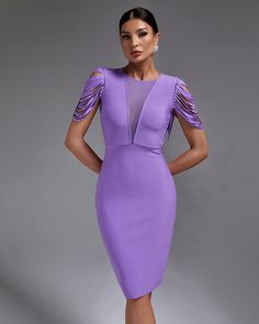 a woman in a purple dress posing for the camera