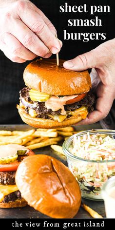 a person is holding a hamburger over some fries