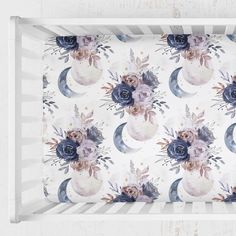 a white tray with blue flowers and crescent moon designs on it, hanging from the wall