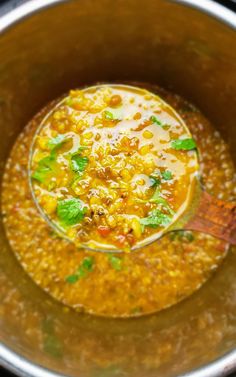 a bowl filled with soup and garnished with parsley on the spoon in it