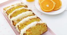 slices of orange cake sitting on top of a pink napkin next to an orange slice