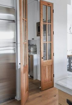 an open door leading to a kitchen with stainless steel appliances