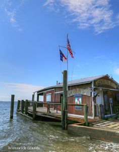 a boat dock with an american flag on it's pole and the water around it