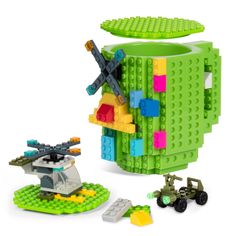 a green lego coffee cup and toy vehicles