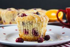 a close up of a muffin on a plate with cranberries and oranges