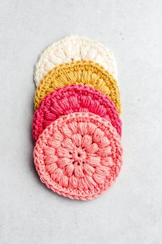 four crocheted coasters sitting on top of each other